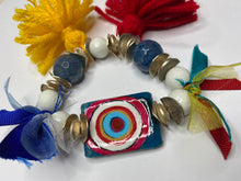 Load image into Gallery viewer, Double Sided Bracelet - 1) Red/White/Blue Evil Eye 2) This too shall pass in Farsi - Blue White silver Beads - Yellow and Red Tassels - Blue Ribbon - #0094
